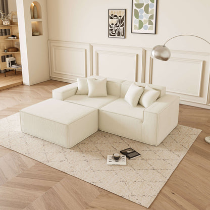 Cube - Sofá Modular 2 Plazas + Puff en Pana Beig en un ambiente moderno y acogedor, con cojines decorativos.