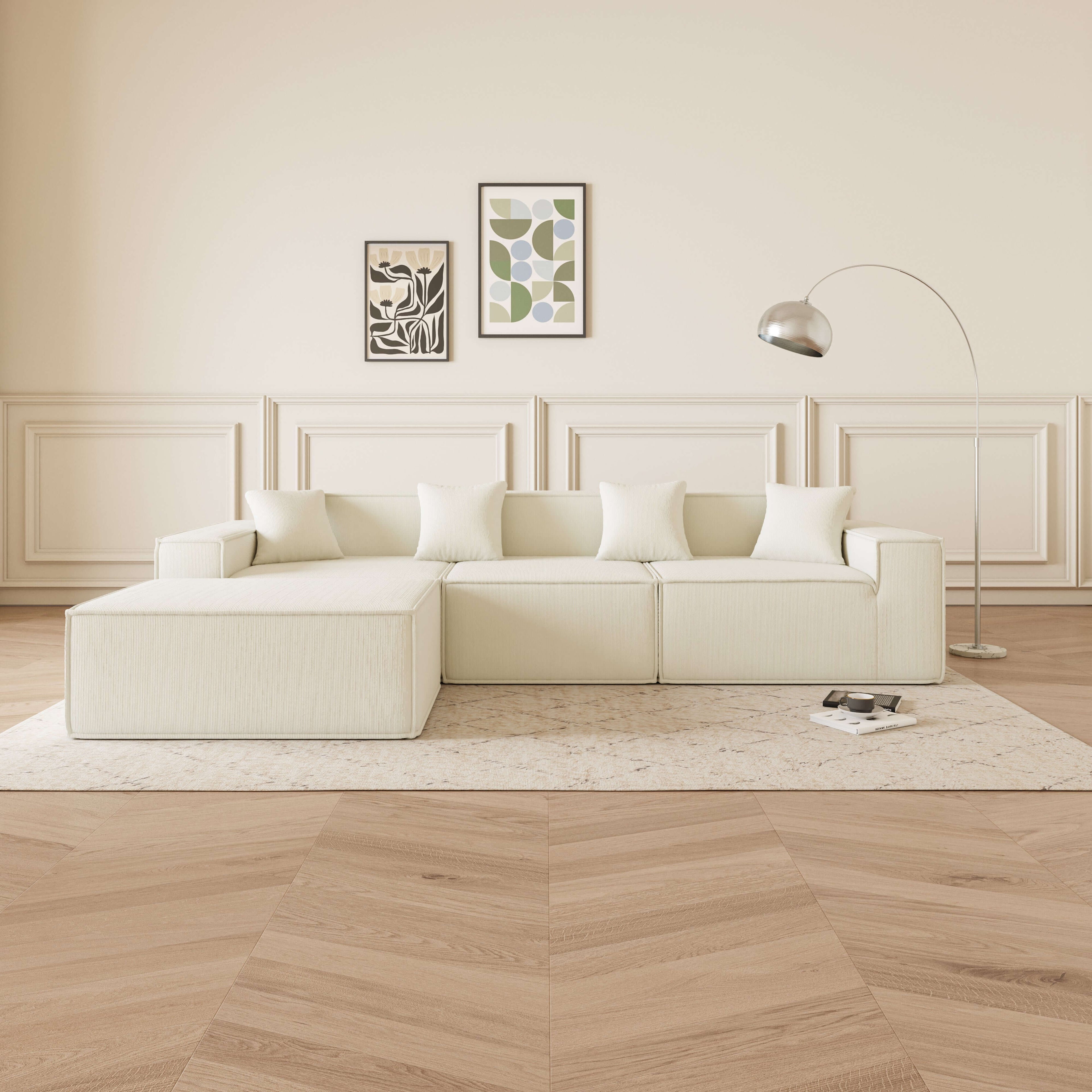 Cube - Sofá Modular 3 Plazas + Puff en Pana Beig en ambiente moderno con almohadas y lámpara de pie.